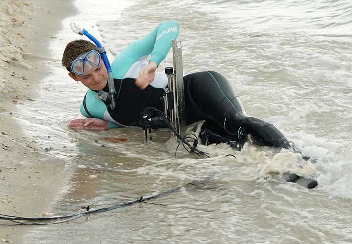 a Vesta scientist taking readings and measurements at the beach